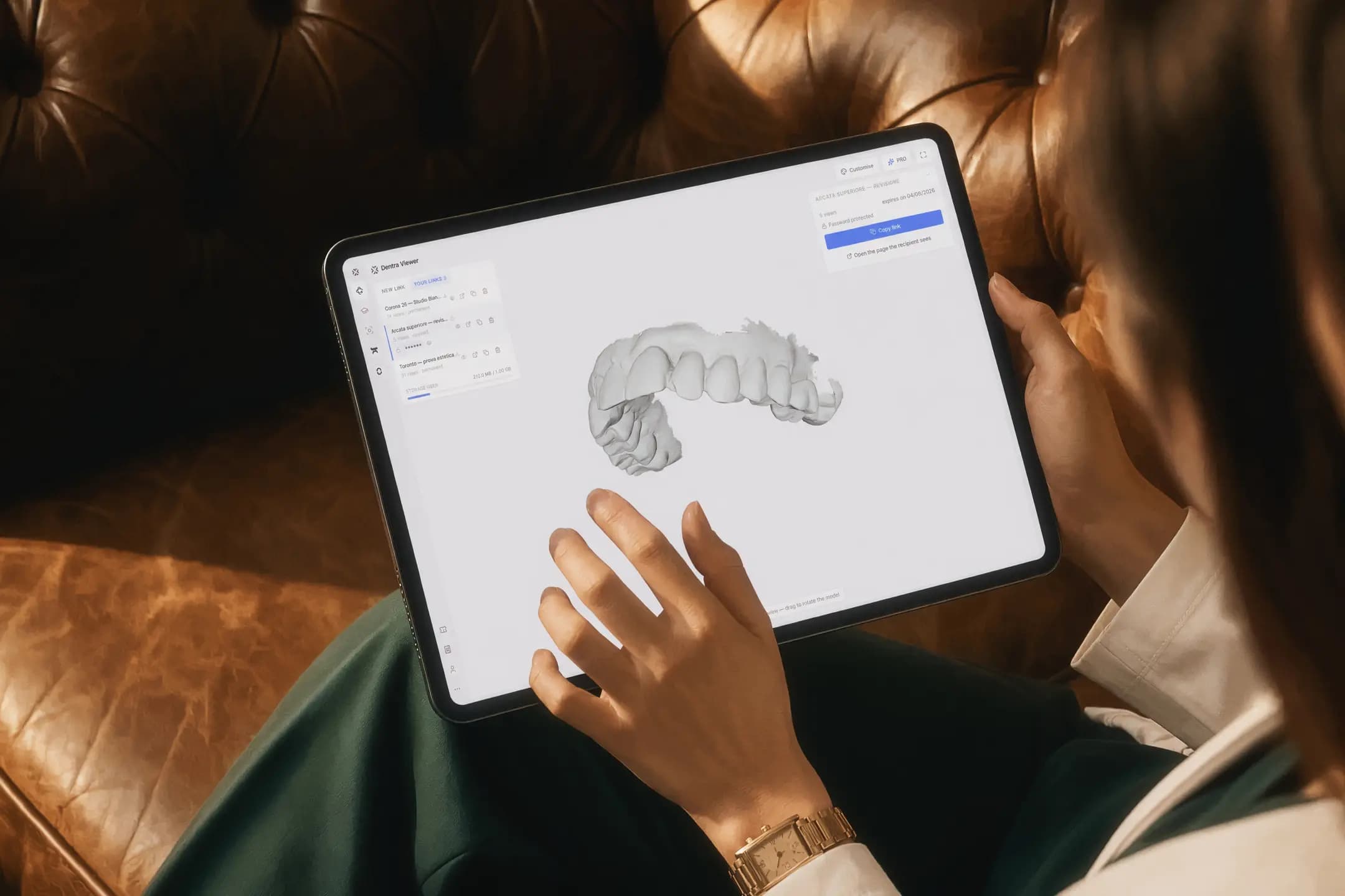 Model 3D otwarty w Dentra Viewer na tablecie trzymanym w dłoni na fotelu
